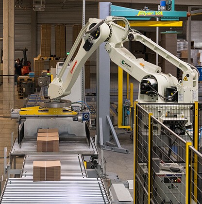 A robot packs finished corrugated cardboard packaging. We then deliver it to the customer using our own logistics.